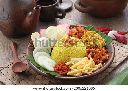 Nasi kuning or sometimes called nasi kunyit (Indonesian for: "turmeric rice"), is an Indonesian fragrant rice dish cooked with coconut milk and turmeric, hence the name nasi kuning (yellow rice). Royalty-Free Stock Photo #2306221085