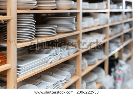 Variety of plates displayed on shelving in household goods store. Kitchen utensils and dishware for sale Royalty-Free Stock Photo #2306222933