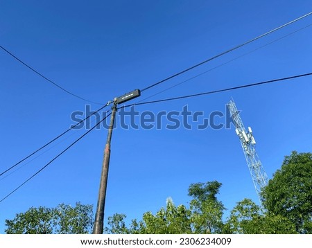 power pole and telecommunication tower with blue sky background