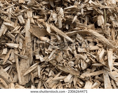 Wood chips for ground cover, wallpaper, mulch, garden use, landscaping, yellow, brown and orange colors, dry leaves, wood texture, sawdust and shavings, high contrast, plant nursery, residential garde Royalty-Free Stock Photo #2306264471