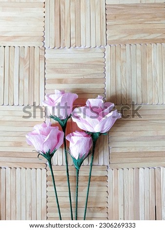 Beautifull paper pink rose flower on wooden background