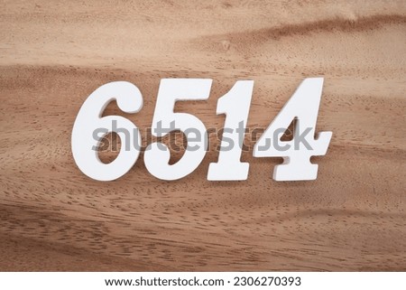 White number 6514 on a brown and light brown wooden background.