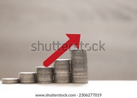Red arrow graph on stack of coins money on white background, investment and business concept