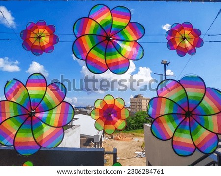Under the blue sky neatly arranged, aesthetic, and variously shaped colorful paper windmills adorn the park in downtown Batam, Riau Islands, Indonesia 