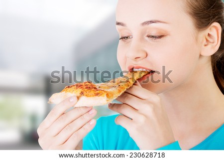 Young beautiful woman eating pizza