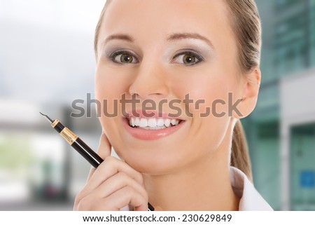 Young business woman holding a pen