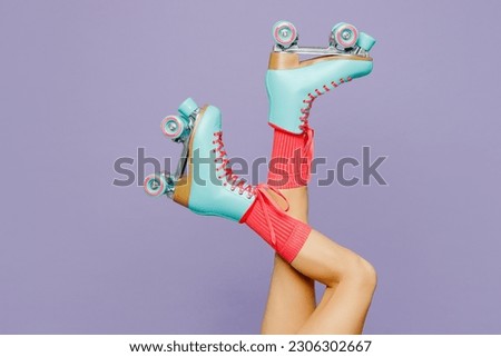 Close up side view cropped raised up female legs in rollerblades rollers isolated on plain light purple violet wall background. Summer sport lifestyle leisure concept. Copy space advertising mock up