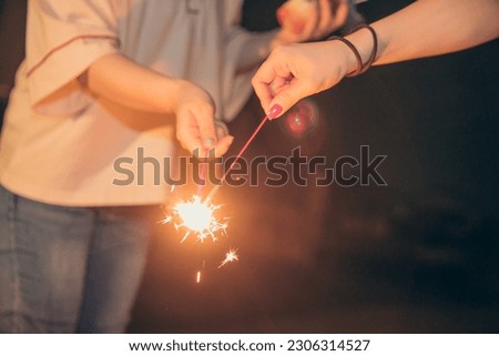 People enjoying handheld fireworks with friends in summer
