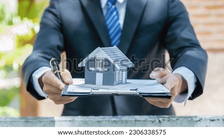 home model in Real estate agent hand and explain the business contract, rent, buy mortgage, loan, or insurance.
