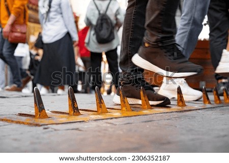 Close-up of yellow spikes for a tire puncture for stopping the car in a street of Istanbul Royalty-Free Stock Photo #2306352187
