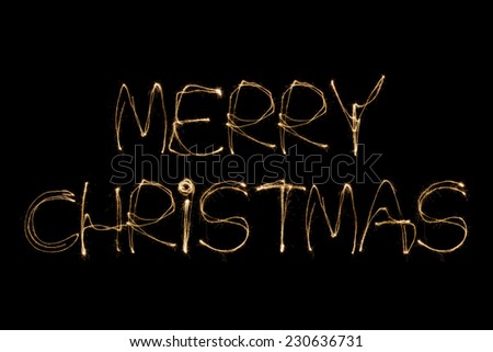 Merry Christmas written with a sparkler isolated on black background