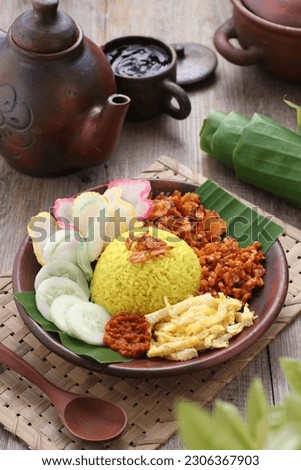 Nasi kuning or sometimes called nasi kunyit (Indonesian for: "turmeric rice"), is an Indonesian fragrant rice dish cooked with coconut milk and turmeric, hence the name nasi kuning (yellow rice). Royalty-Free Stock Photo #2306367903