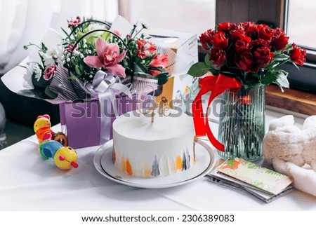 Happy birthday! Close up image first birthday sweet cake surprise number one inscription with burning candle, presents gifts flowers
