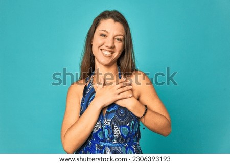 A young caucasian woman isolated has friendly expression, pressing palm to chest. Love concept.