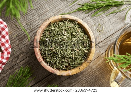 Dried horsetail herb in a bowl on a table, top view. Alternative medicine. Royalty-Free Stock Photo #2306394723