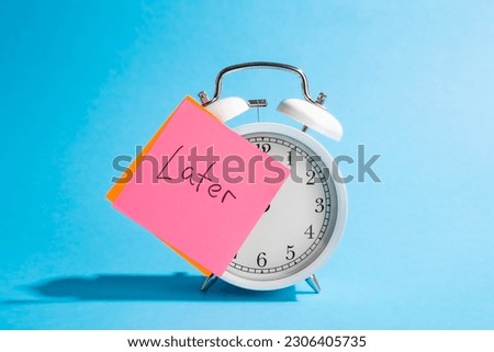 White alarm clock and sticker with the inscription Late on a blue background.