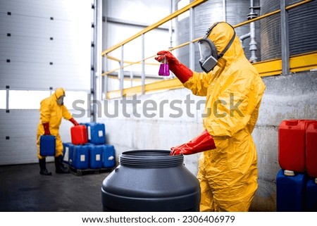 Factory expert in protection equipment checking quality of chemicals in production plant. Royalty-Free Stock Photo #2306406979