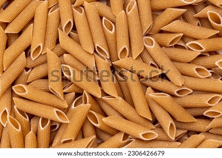 Background from pasta. Penne, Penne Rigate. Top view, close-up. Royalty-Free Stock Photo #2306426679