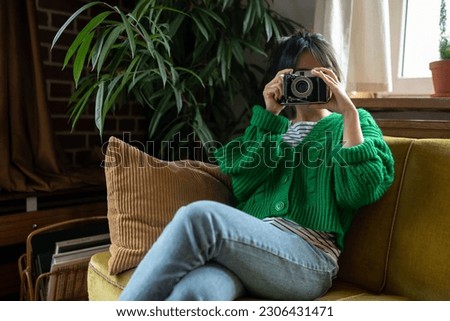 Girl in green shirt with a camera in hands
