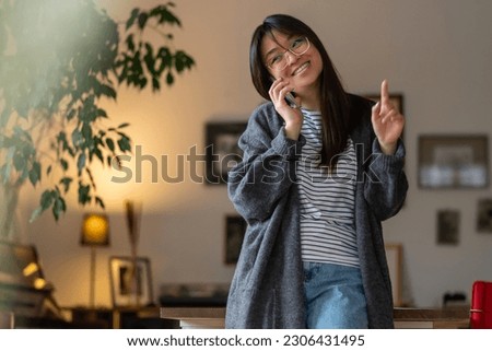 Contented young asian girl talking on the phone