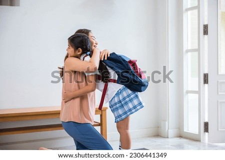 Loving mother and schoolgirl with backpack before first day, Asian mother hugging her daughter saying goodbye before go to school at home, parents and child little girl, back to school concept Royalty-Free Stock Photo #2306441349