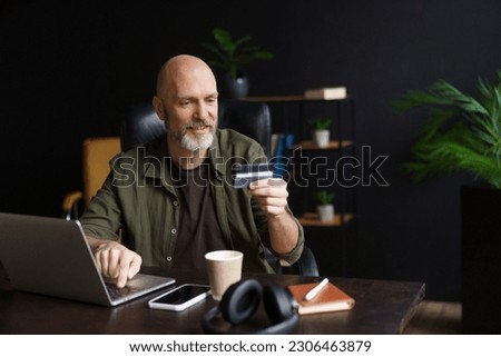 Online shopping, satisfied customer completes purchase. Customer use computer to browse goods. He enters data from credit card to make secure payment on online store's website. High quality photo