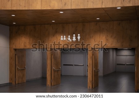 Public toilet signs on wooden wall over entrance