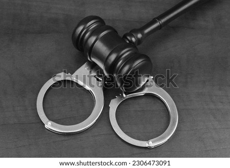 Wooden gavel on handcuffs close up. Arrest and justice concept. Royalty-Free Stock Photo #2306473091