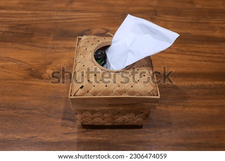 A box of tissue paper made from bamboo plait placed in wooden table, top view 