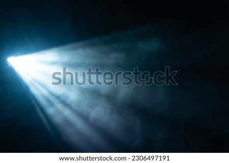 blue spotlight light beam on black background Royalty-Free Stock Photo #2306497191