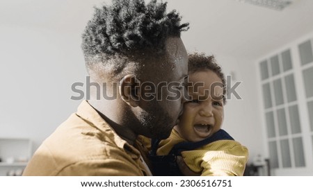 Single father tries to comfort his crying son, facing the difficulties of fatherhood Royalty-Free Stock Photo #2306516751