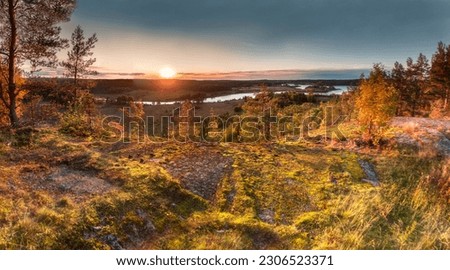 Dawn and sunset over a lake with rocks, islands, and forest