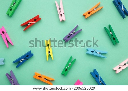 Colored wooden clothespins on mint background. Design elements. Macro. Space for text Royalty-Free Stock Photo #2306525029