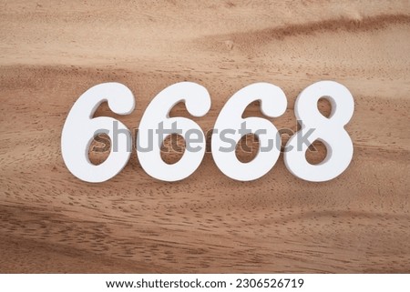 White number 6668 on a brown and light brown wooden background.
