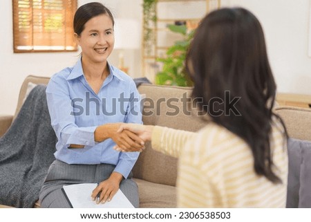 Female psychologist and patient shaking hand after successfully in treatment at psychology session.