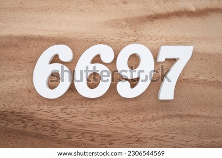 White number 6697 on a brown and light brown wooden background.