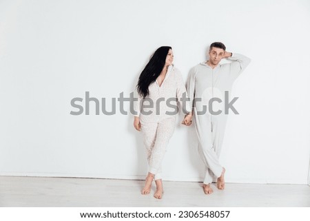 woman and man in pajamas in a bright room on a white background husband and wife lovers