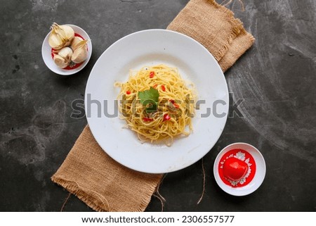aglio e olio. Italian Pasta Spaghetti, aglio olio e pepperoni ,spaghetti with garlics, olive oil and chilli peppers on plate on table Royalty-Free Stock Photo #2306557577