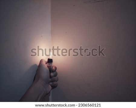  a man holds in his hand a lit gas lighter with a flame, a fire for lighting cigarettes, hand holding a lighters, Hand holding lighter to ignite on dark background, Portable device used to create a fl