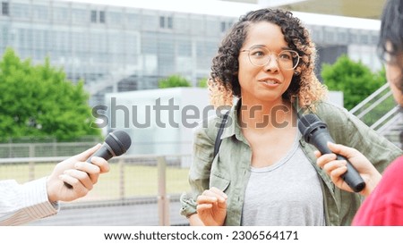 African woman being interviewed on the street by the media. Royalty-Free Stock Photo #2306564171