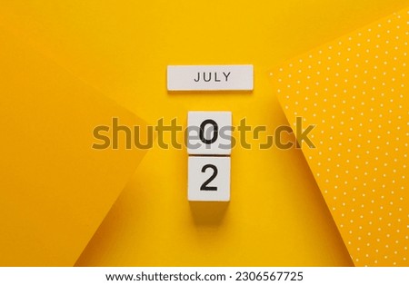 White calendar cubes with date july 02 on yellow background. Creative layout