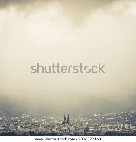 view of the city of Clermont-Ferrand and its black cathedral in the Puy-de-Dôme in Auvergne under a stormy sky Royalty-Free Stock Photo #2306572163
