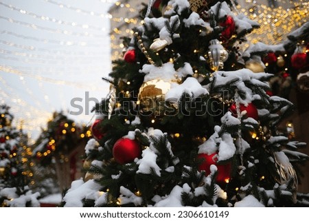 beautiful multi-colored toys on a Christmas tree against the background of lights and snow