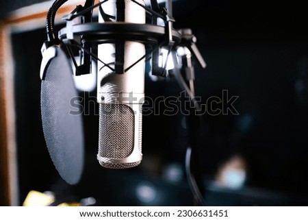 Professional condenser microphone on the microphone holder in sound - audio recording studio. 
