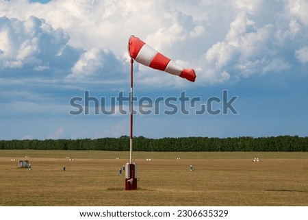 Airport wind sock. Strong wind and bad weather symbol. Climate change. Meteorology forecast. Storm is coming. Royalty-Free Stock Photo #2306635329