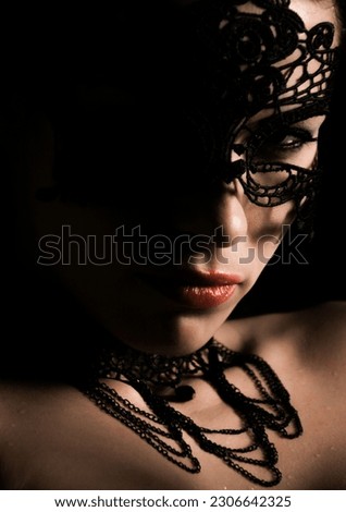 A vertical closeup shot of a mysterious girl face with a dark lacy mask Royalty-Free Stock Photo #2306642325