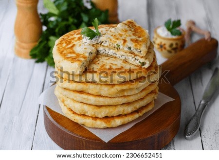 Cheese Stuffed Flatbread. Homemade Delight on Wooden Board with Sliced Flatbread. Selective Focus, horizontal, light wooden table Royalty-Free Stock Photo #2306652451