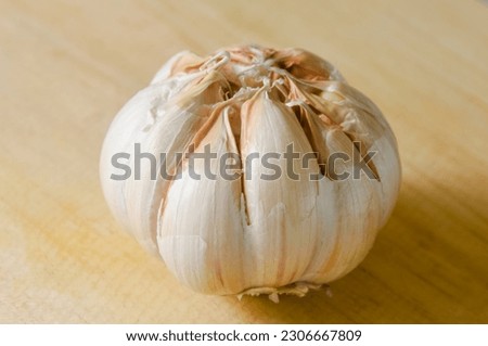 Fresh garlic bulb on a wooden cutting board.