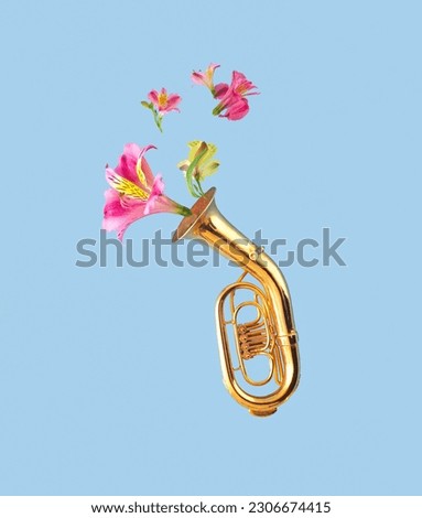 Minimal creative concept of tuba musical instrument with flying colorful seasonal flowers.