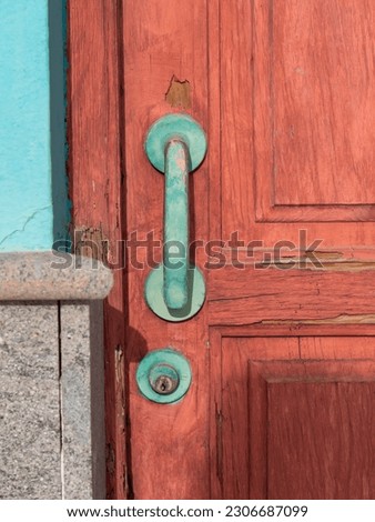 Partial shot old reddish wooden door with green door handle